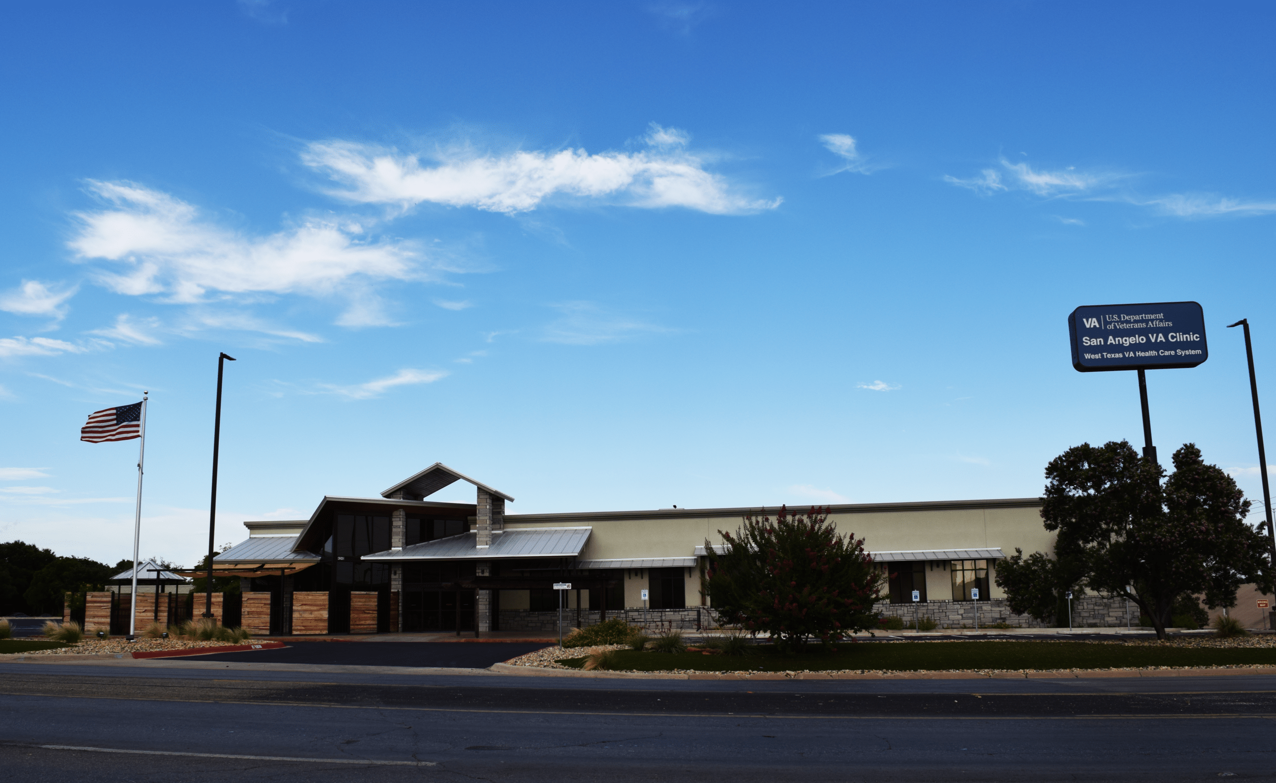 San Angelo VA Clinic exterior with US flag under a blue sky.