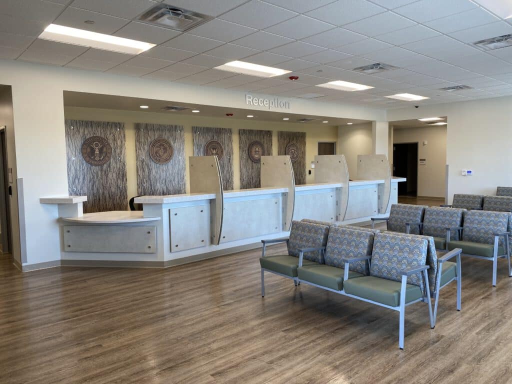 Modern reception area with seating and a 'Reception' sign above the desk.