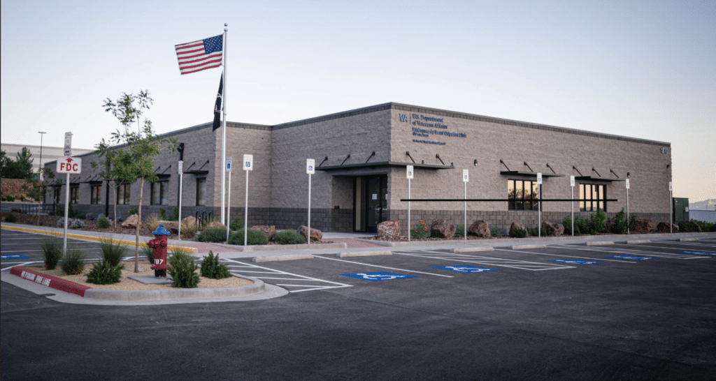 VA U.S. Department of Veterans Affairs building with American flag and parking lot.