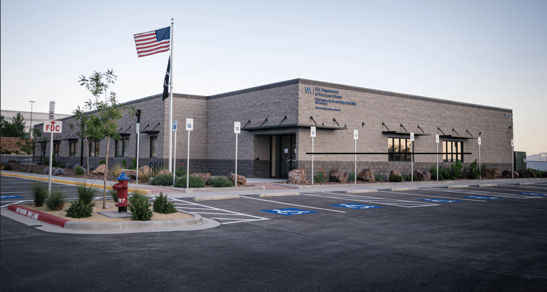 VA U.S. Department of Veterans Affairs building with American flag and parking lot.