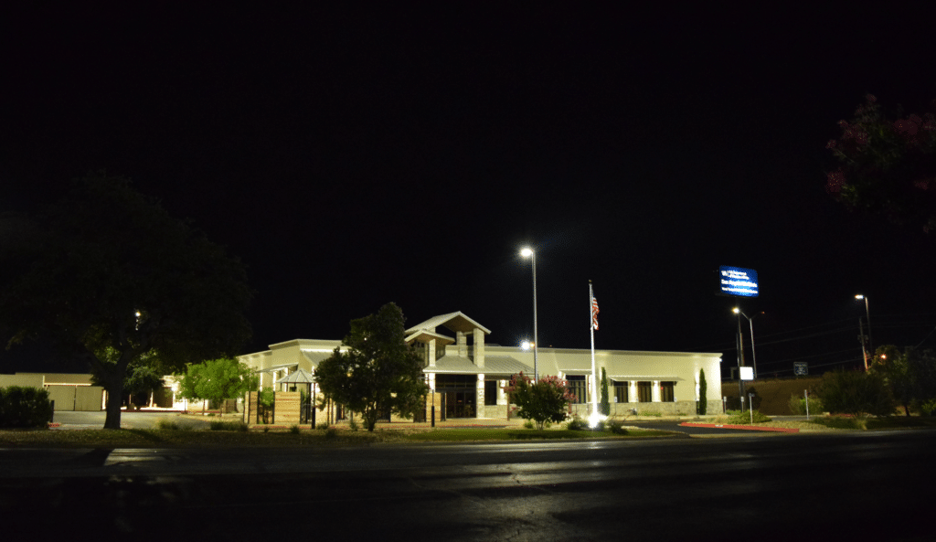 Commercial building at night with American flag. Portfolio image.