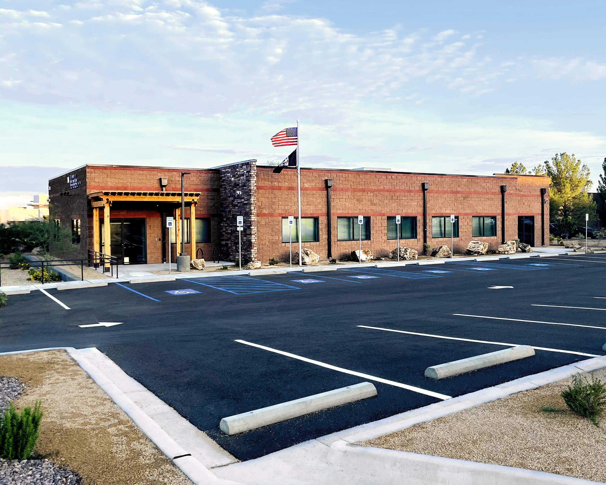 Modern brick building with accessible parking and US flag. Portfolio showcase.