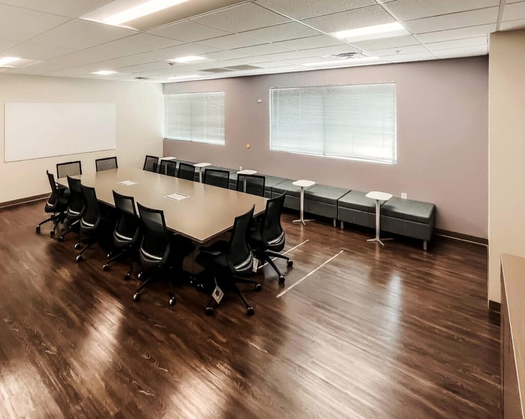 Conference room with a long table, chairs, and bench seating.
