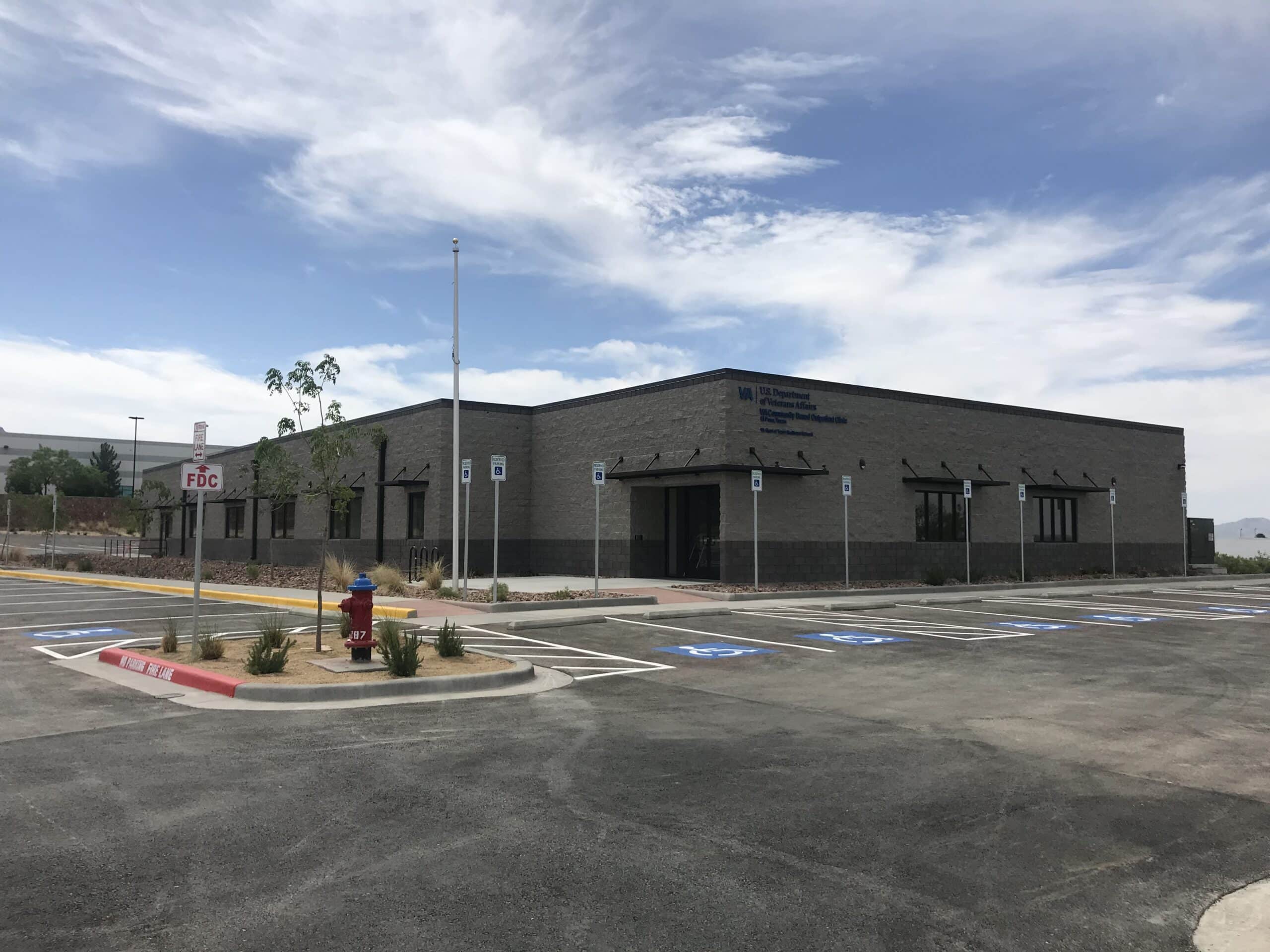 Single-story building with parking lot and blue skies, labeled U.S. Department of Veterans Affairs.